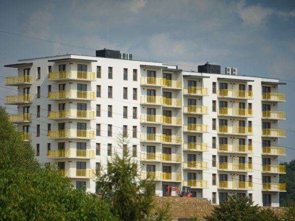 High-density modern affordable housing apartment block with yellow balconies, representing mid-market urban real estate in Kenya