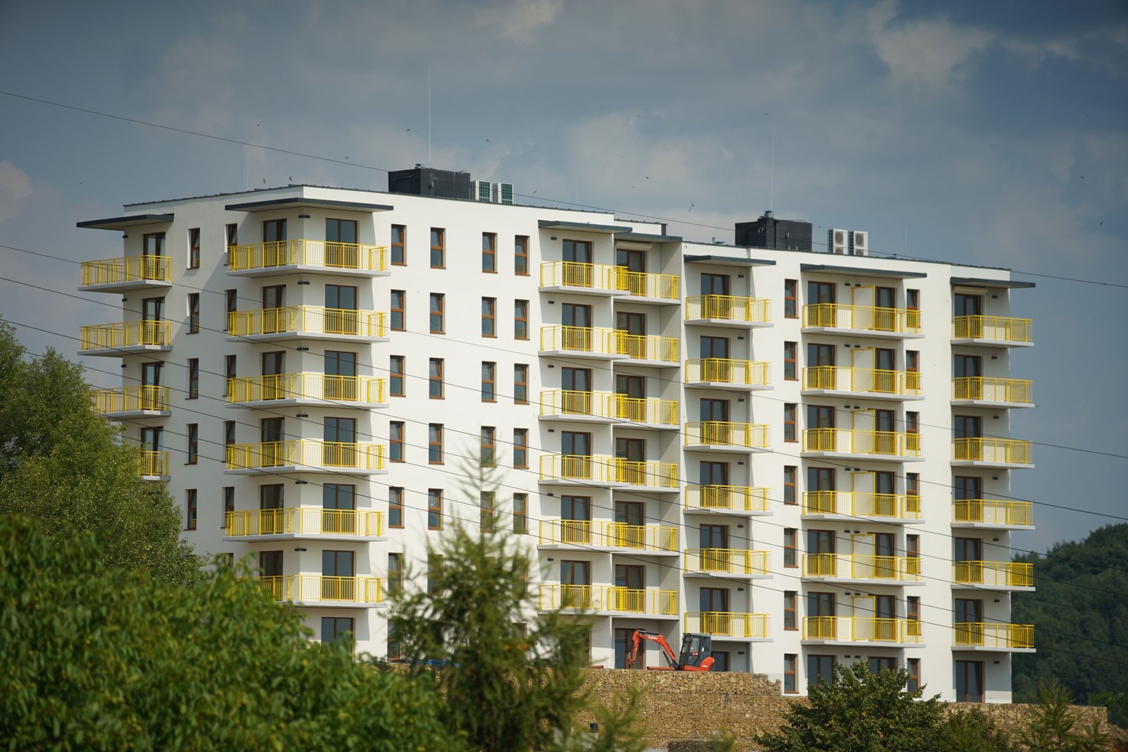 High-density modern affordable housing apartment block with yellow balconies, representing mid-market urban real estate in Kenya