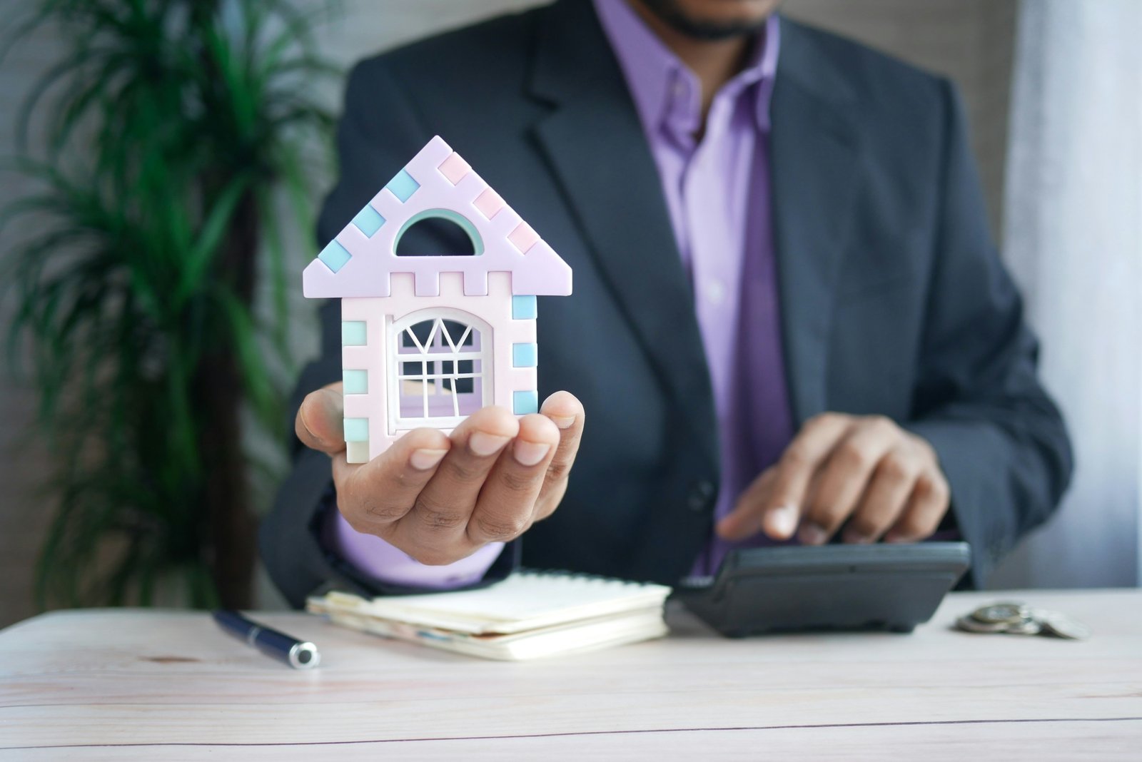 Close-up of a property investor using a calculator to calculate the return on investment (ROI)
