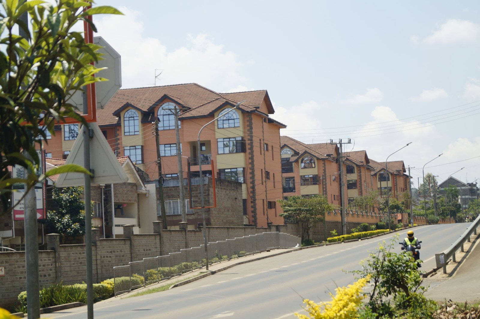 Modern gated residential apartment blocks with paved access road and security perimeter